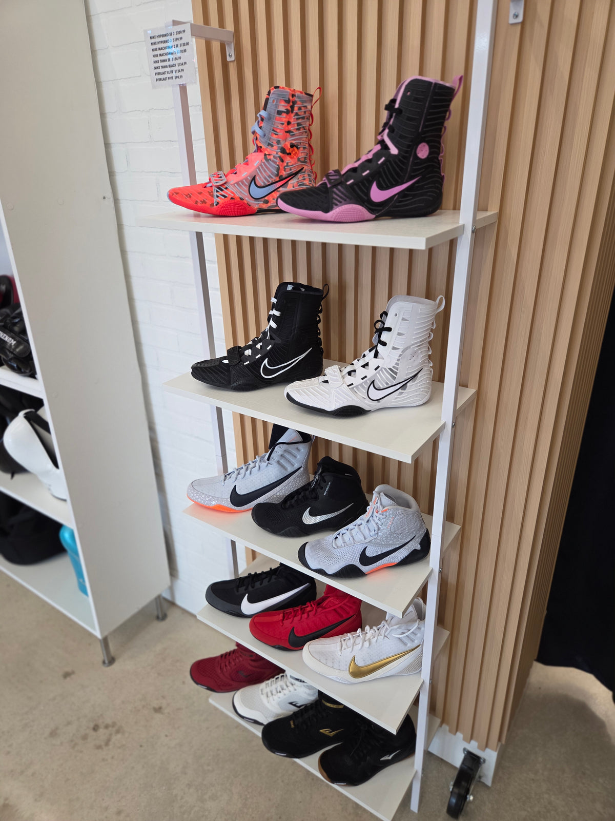 Shoe display rack with various sneakers on a neutral background