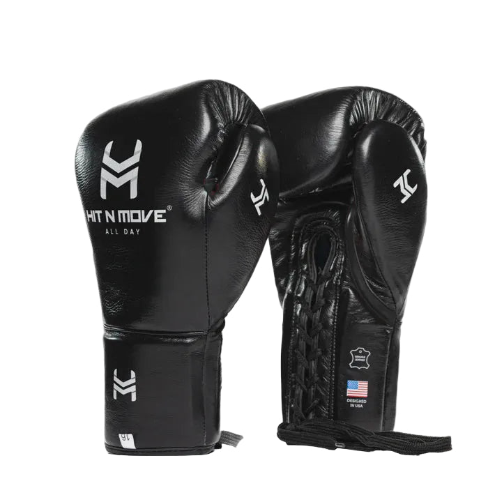 A pair of black leather boxing gloves with white branding and details, shown against a light gray background.