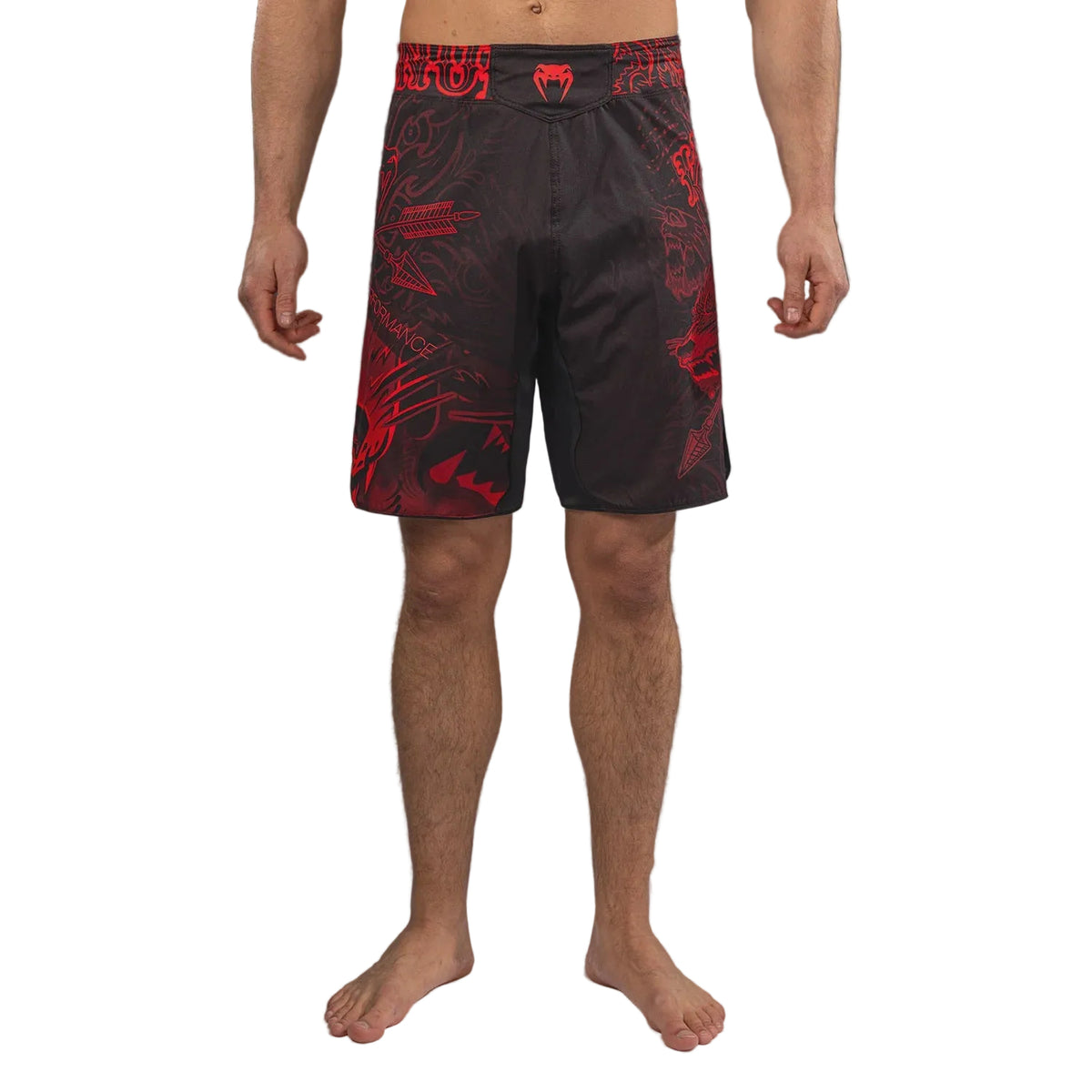 A man modeling black and red patterned athletic shorts, shown from the waist down against a gray studio background.