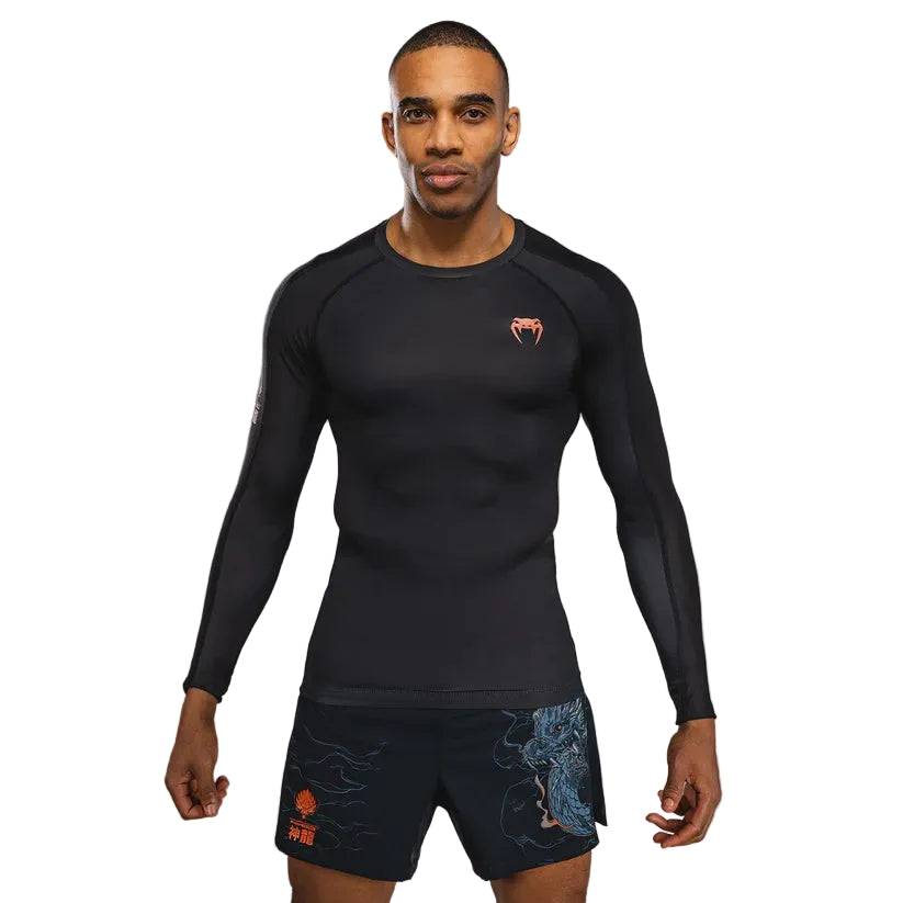 Man wearing a black athletic outfit with a logo on a gray background