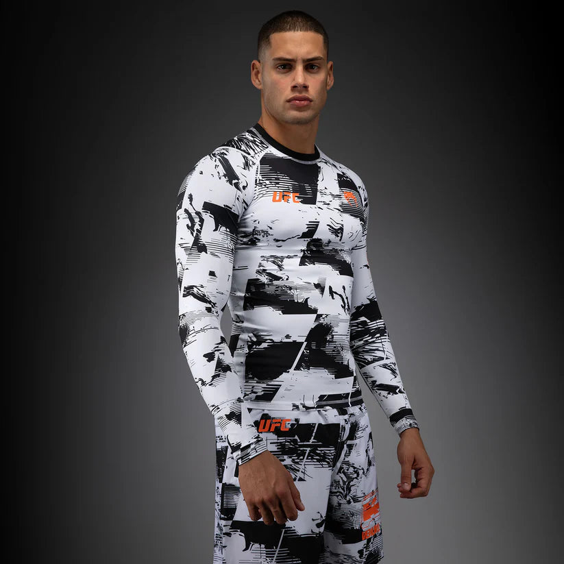 Person wearing a black and white UFC branded compression suit on a dark background